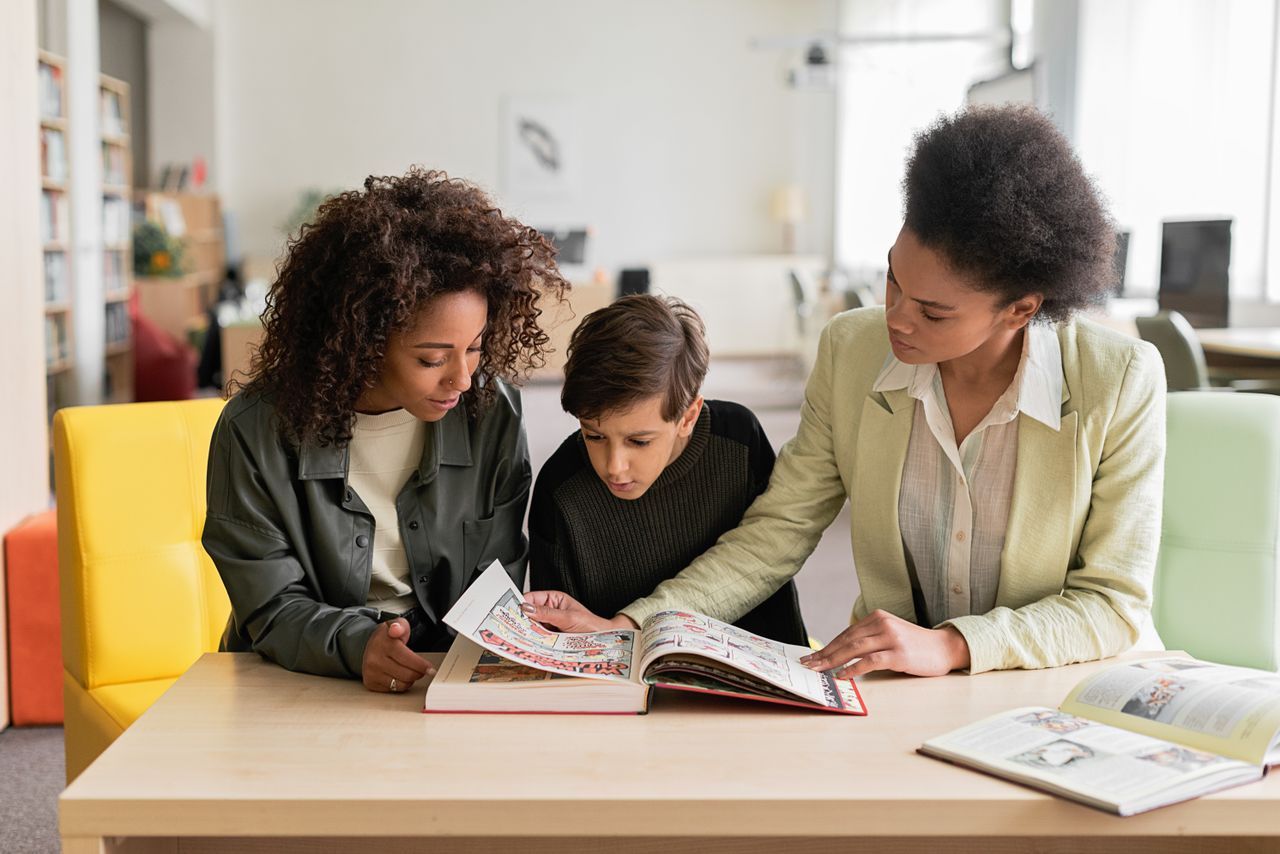 A family reads together at a table, enhancing learning and bonding indoors.